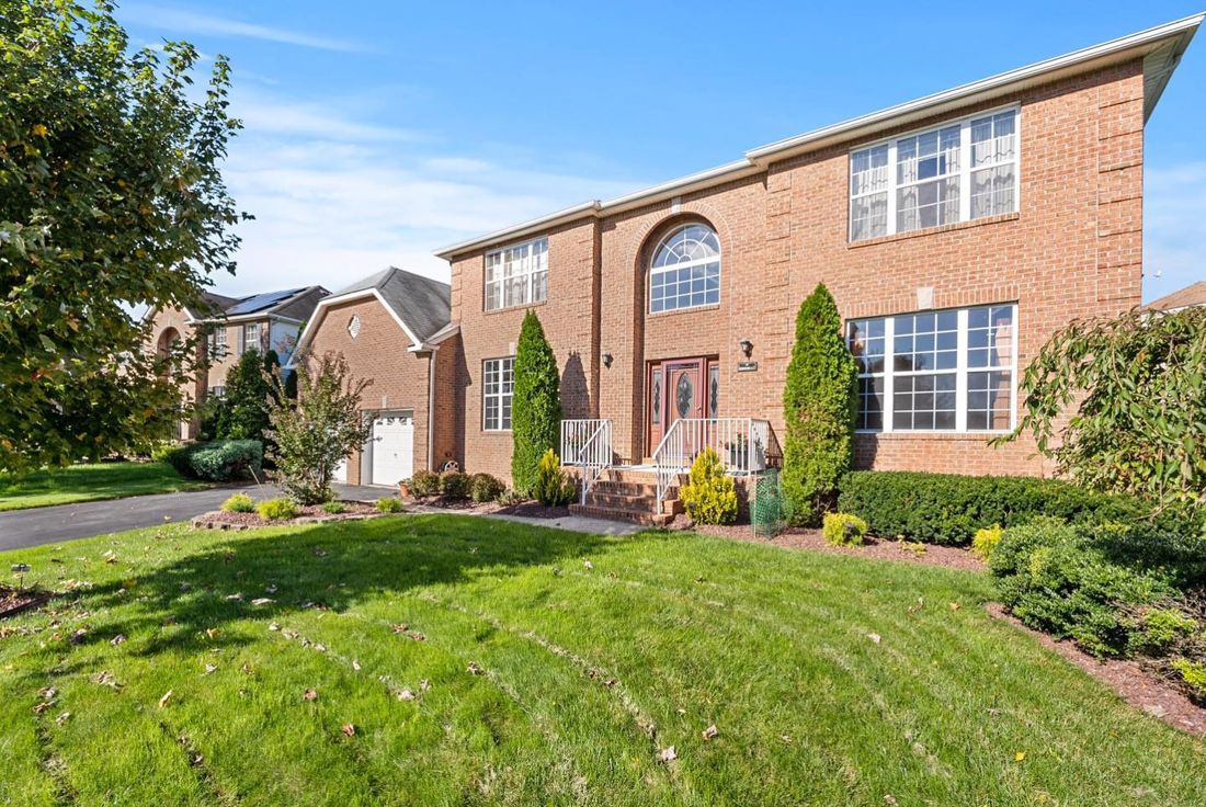 Brick colonial home with landscaped front lawn